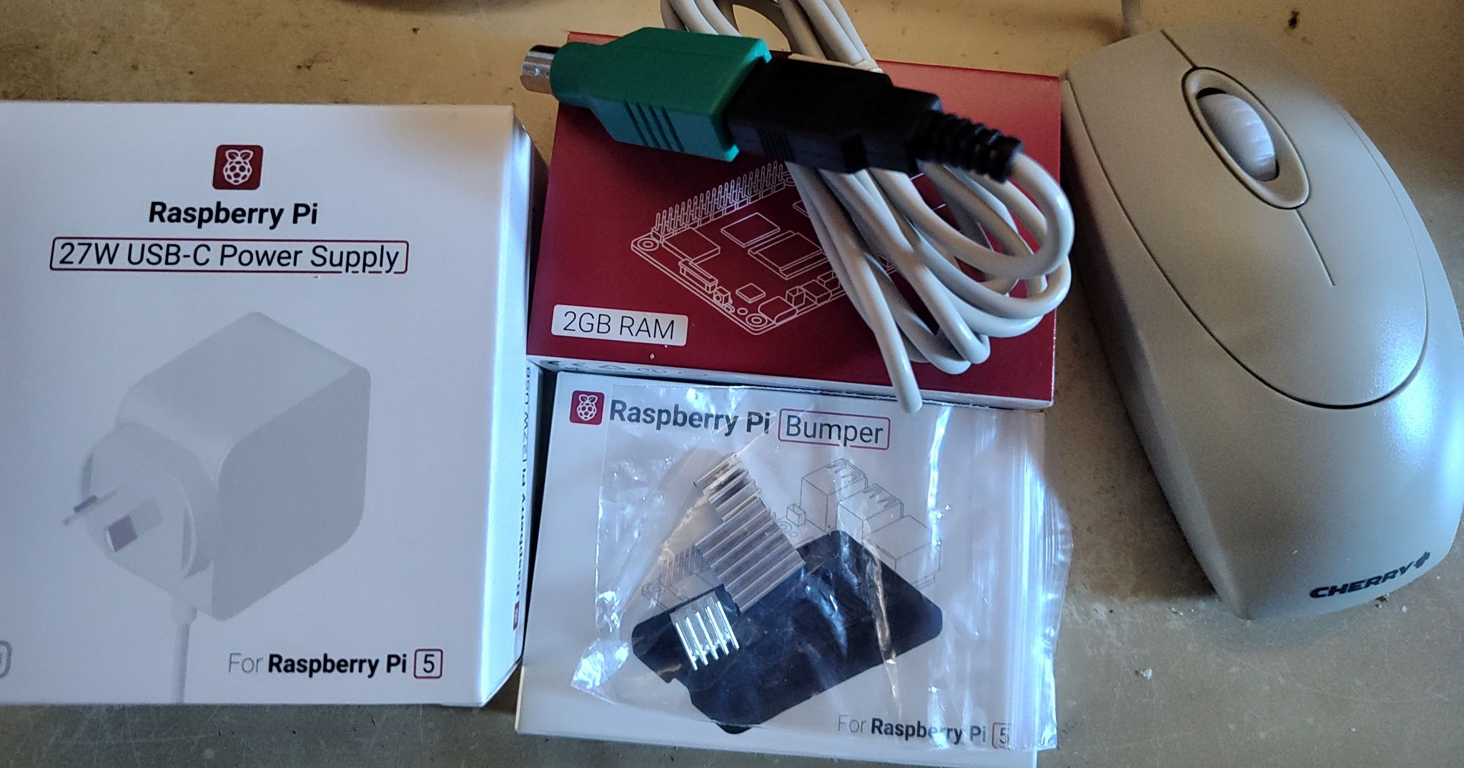 A raspberry pi, with bumper case, heat sinks, and power supply, and a retro beige mouse