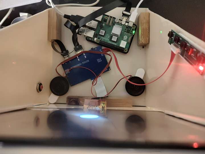 top-down view showing the contents, a raspberry pi, some control boards for the LCD, and two speakers